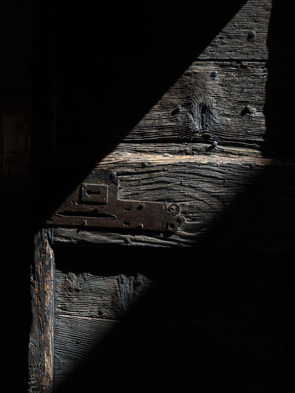 Vieille porte en bois éclairée par un rayon de lumière à Cordes-sur-Ciel dans le Tarn