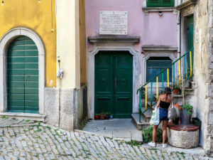 femme-short-facade-jaune-rose-rue-pavee-labin-croatie