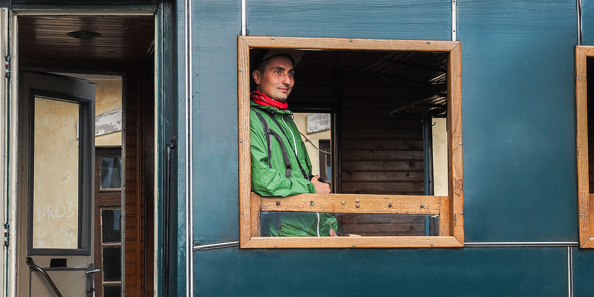 Homme en vert à la fenêtre du train de Sargan en Serbie