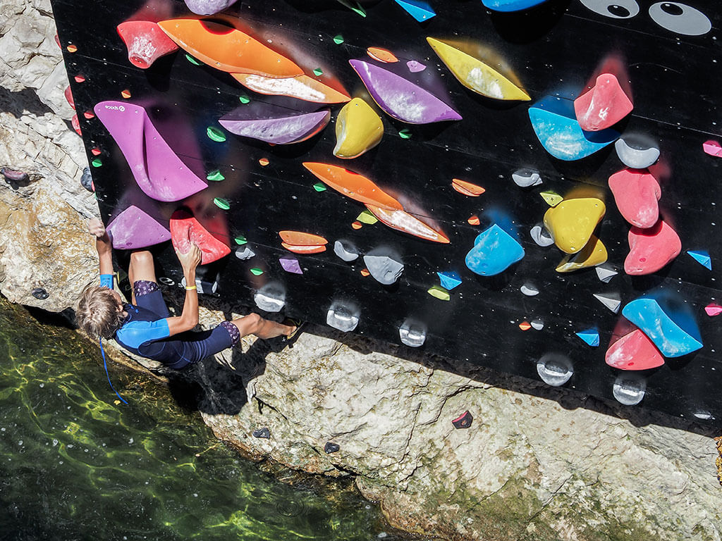 jeune-homme-escalade-mur-riviere