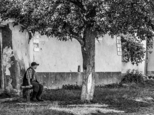 homme-assis-banc-rue-viscri-roumanie