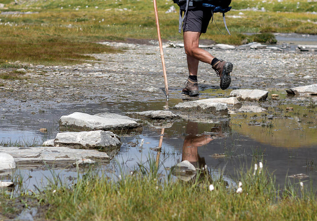 randonneur-baton-reflet-ruisseau-alpes