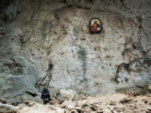 homme-assis-telephone-icone-religieux-grotte-prohodna-bulgarie