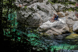 baigneurs-assis-rocher-riviere-vallee-verzasca-suisse