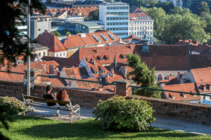deux-femmes-assises-banc-parc-tour-horloge-graz-autriche