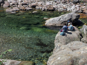 Une famille mange sur un rocher de la rivière Verzasca en Suisse