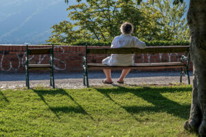 homme-assis-banc-parc-tour-horloge-graz-autriche