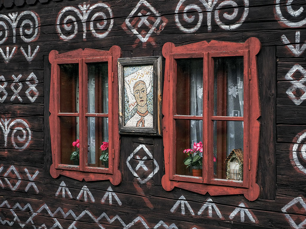 Deux fenêtres et un portrait d'une maison décorée du village de Cicmany en Slovaquie