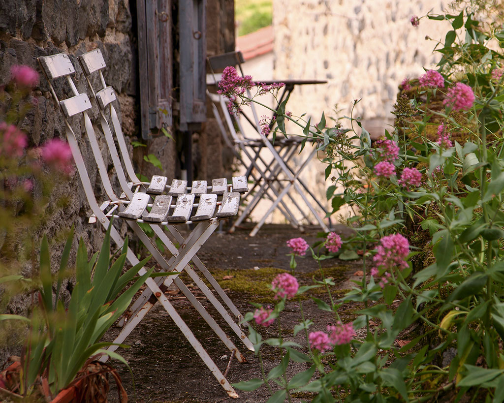 Deux chaises vides en bois sont posées côte à côte sur une terrasse un jour ensoleillé