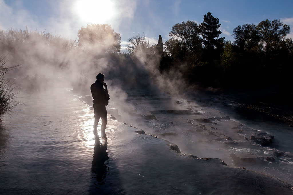 Un homme les pieds dans l'eau dans un bassin des thermes de Saturnia en Italie