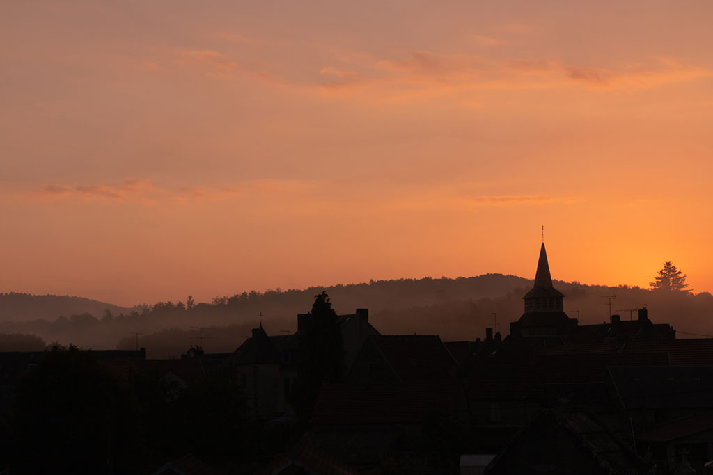 Lever de soleil orangé au dessus du village de La Chapelle Taillefert en Creuse