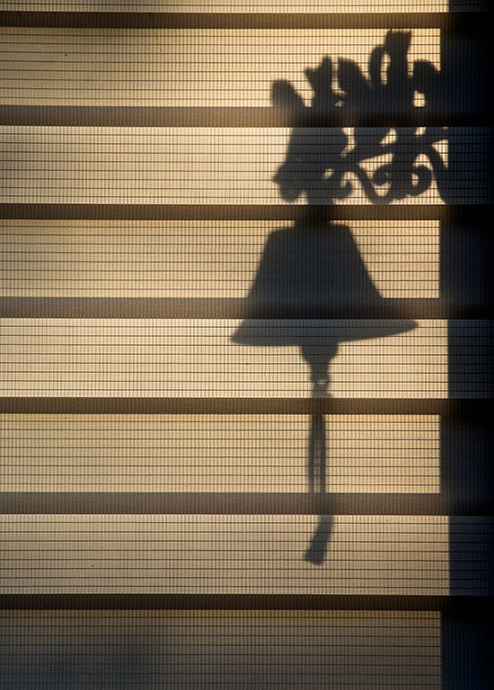 Silhouette d'une cloche devant la porte d'une maison